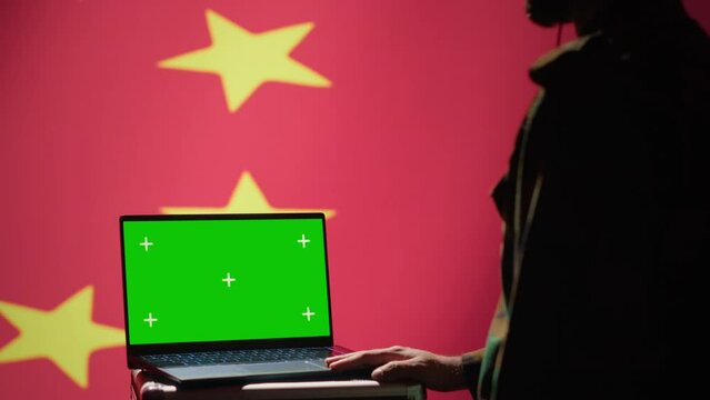 Chinese secret police agent uses mass propaganda tools on chroma key laptop to influence population minds. Communist Party regime commits PsyOp sabotage using notebook, camera A