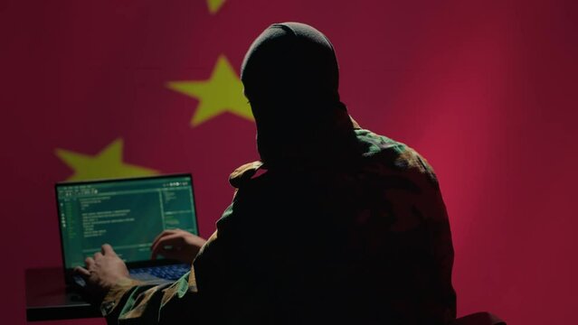 Chinese terrorist using software algorithms on laptop to do fundamentalism propaganda on internet. CCP government secret agent wearing mask sharing dangerous illegal malware online, camera A