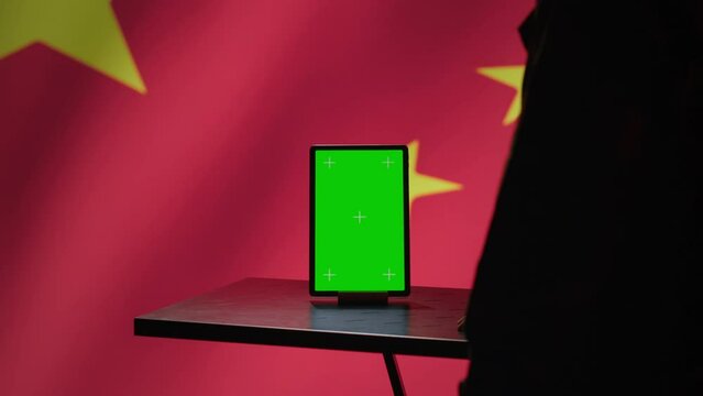 Chinese engineer uses green screen tablet to make fake accounts on social media promoting communist ideology. Technician doing cybersecurity job for CCP government with mockup device, camera A