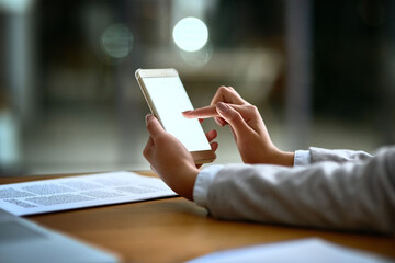 Business person, hands and browsing with phone screen at night for online research or news at office desk. Closeup of employee working late on mobile smartphone for web search, app or communication