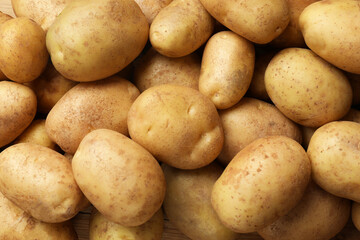 Many fresh potatoes as background, top view
