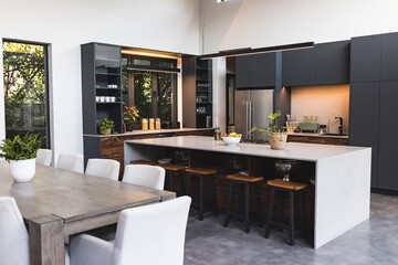 Modern kitchen with large island, bar stools, and dining table in contemporary home