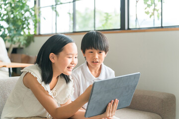 Obraz premium 家でタブレットPC・タブレット端末を使う子供達 