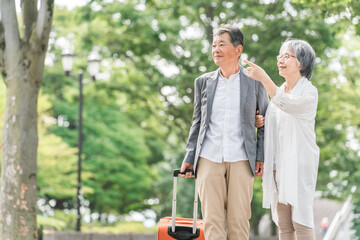 スーツケースを持って旅行する高齢者夫婦（シニアライフ・アクティブシニア）  © buritora