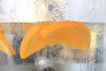 Fresh ripe orange in dirk water for refreshing in jar during summer season. Health and diet...