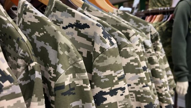Pixel Camouflage T-Shirts on Circular Rack: Military Clothing Store Display | Army Gear and Combat Apparel Merchandise Showcase