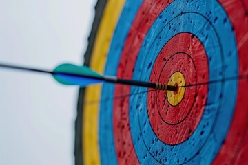 Arrow hitting bullseye on colorful target