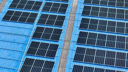 Obraz premium top view of grid of technology renewable solar energy. construction solar panels system on roof. Installing solar photovoltaic panel system. background of blue of solar cell system and structure roof.