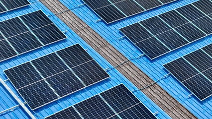 Fototapeta premium top view of grid of technology renewable solar energy. construction solar panels system on roof. Installing solar photovoltaic panel system. background of blue of solar cell system and structure roof.
