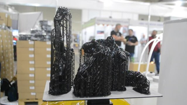 Black model with supports printed on 3D printer close-up. Part of object created on 3D printer from hardened rubber under influence of ultraviolet light. SLA 3D printing technology. Stereolithography