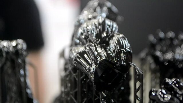 Black model with supports printed on 3D printer close-up. Part of object created on 3D printer from hardened rubber under influence of ultraviolet light. SLA 3D printing technology. Stereolithography