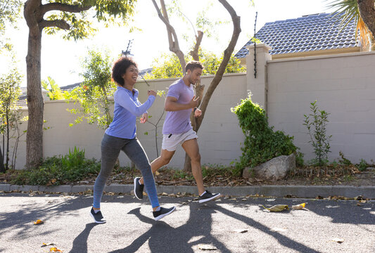 Jogging together, couple enjoying outdoor exercise in residential area