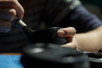 Photograph of hands cleaning a camera lens. Concept of photography.