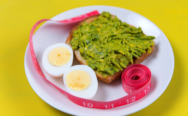 Food for weight loss. Egg, avocado, toast, meter. Cooking healthy food at home. Food on a yellow background.