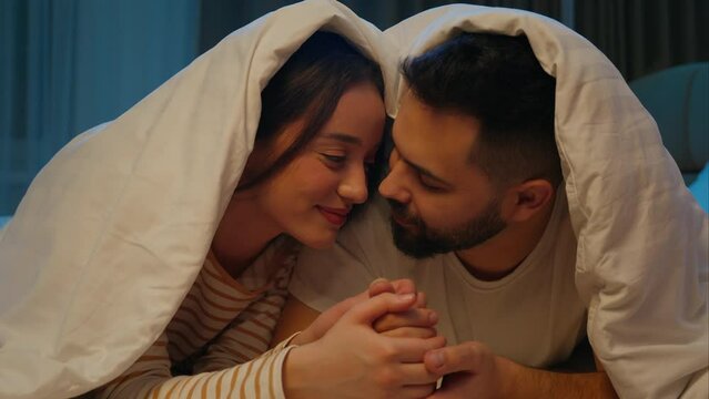 Man woman boyfriend girlfriend kiss on cheek rub noses couple love husband wife female male harmony feelings sweetheart honeymoon romance bonding beloved affectionate tenderness duvet bed bedroom home