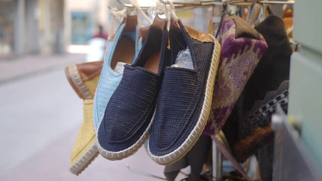 Fashion accessory A variety of shoes hanging on a city street rack