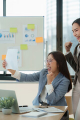 Excited businesswomen celebrating successful project in office. Concept of workplace achievement and teamwork