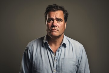 Fototapeta premium Portrait of a middle aged man in a blue shirt on a dark background