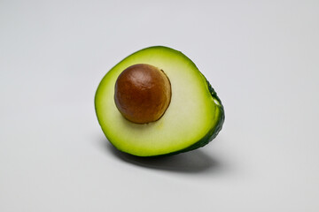 Avocado fruit is greenish yellow in color and has a large brown seed with a perspective position