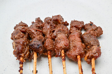 Satay with peanut sauce and soy sauce topped with chili slices and shallots is an Indonesian delight. Juicy grilled meat skewers paired with rich, spicy, and savory sauces.