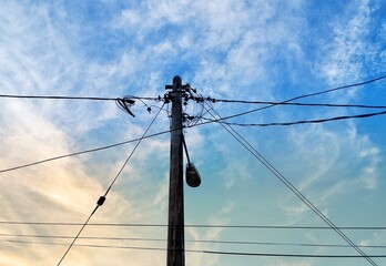 Electric pole with wires under the sky background 