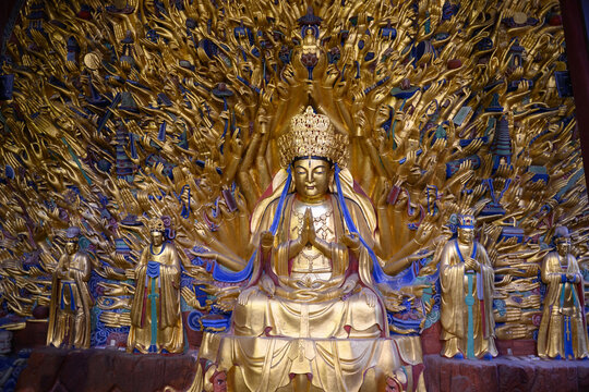 Golden sculpture of Guanyin with thousand hands at Dazu Rock Carvings at Mount Baoding or Baodingshan in Chongqing, China. UNESCO World Heritage.