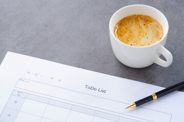 コーヒーを飲みながら、やるべきこと、日付、締切日を記入する「TO...