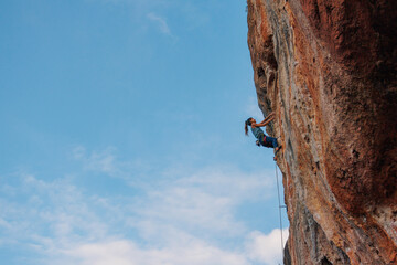 silhouette of a girl climber. rock climber girl climbs an overhanging rock.