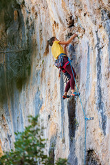 rock climber girl. rock climbing as an Olympic sport. strong girl. A girl climbs a rock.