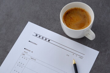 コーヒーを飲みながら、転職活動に欠かせない職務経歴書を書く
