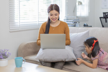 Portrait of a young happy female freelancer sitting on the couch and working on project, watching movie on laptop, studying, blogging, resting and chatting online. High quality photo