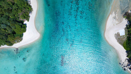 The aerial view of white sand beach tropical with seashore as the island in a coral reef ,blue and turquoise sea Amazing nature landscape with blue lagoon © SASITHORN