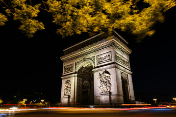 Fototapeta premium Nighttime View of the Arc de Triomphe with Light Trails - Paris, France