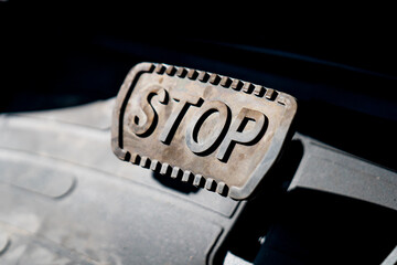 Big braking car pedal with large letters of "STOP" on it as signal for stopping 