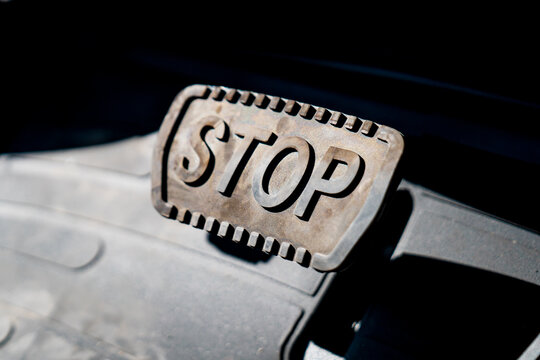 Big braking car pedal with large letters of "STOP" on it as signal for stopping