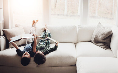 Upside down, reading books and boys on couch, hobby and activity with fantasy, storytelling and...