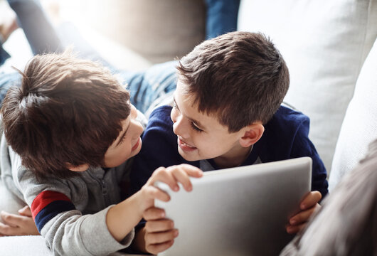 Family, kids and siblings with tablet on sofa for movie, search or gaming while bonding in their home together. Digital, love and boy children in living room with elearning, ebook or storytelling app