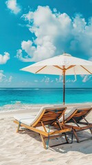 Beach chairs and umbrella on white sand