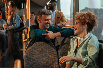 Middle-aged man laughing with a young woman on a bus
