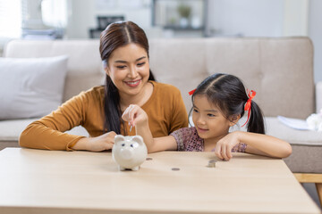 Setting good example. Young parent mother teach child little daughter girl to manage finances save...
