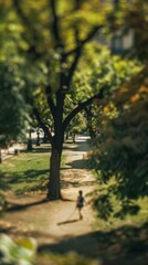 Fototapeta premium Lone person walking on path through lush green park on sunny day. Concepts. solitude, nature, peace, tranquility, city park.
