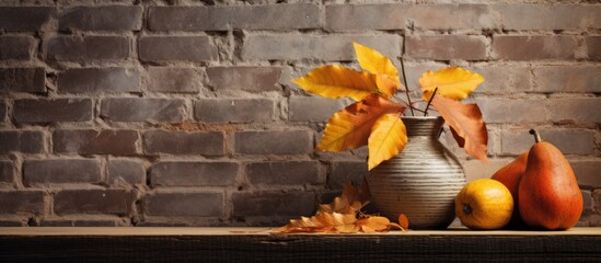 A display of autumn leaves and a petite orange gourd decorates a worn brick wall with a charming rustic allure, creating an inviting copy space image.