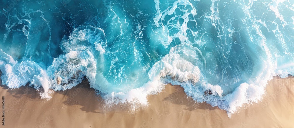 Poster aerial perspective captures ocean wave crashing against beach with prominent copy space image.