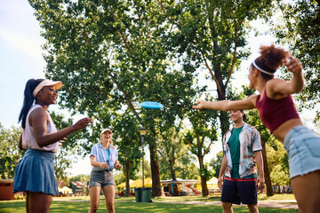 Obraz premium Group of happy friends playing with frisbee in nature.