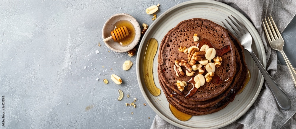 Poster delicious healthy breakfast snack featuring chocolate pancakes topped with honey and nuts on a plate