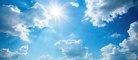 Sunny summer sky with curly white clouds on a bright blue background; depicts heaven's infinite beauty with good weather, creating an ideal copy space image.
