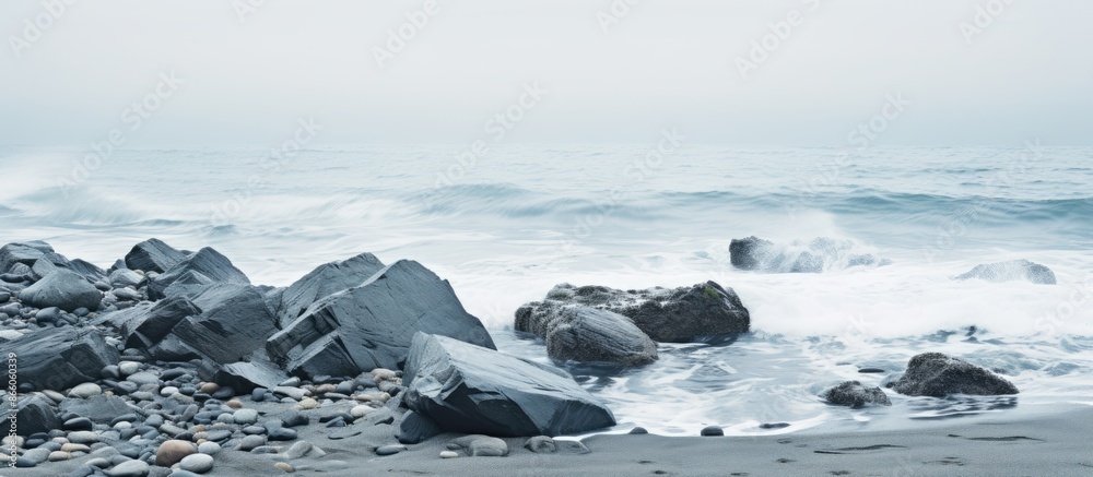 Aufkleber seaside scene with gray rocks amidst the sea and white foamy waves along the shore creating a tranqu