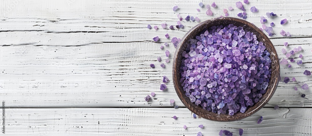Poster a bird's-eye view of lavender sea salt crystals in a bowl on a white wooden surface, offering space 