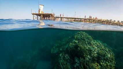 View of the pier with tourists on a sunny day Underwater split shot photos