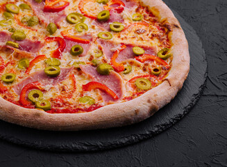 Delicious italian pepperoni pizza with olives on slate